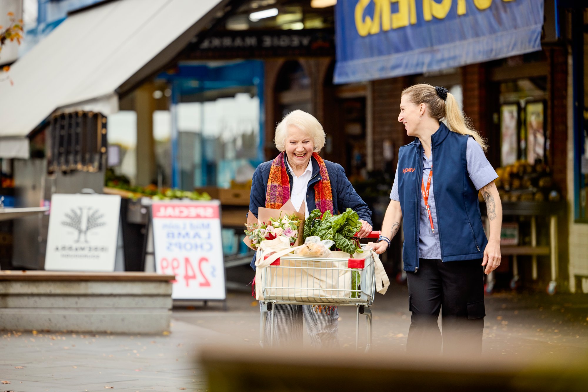 A support worker helping an older lady with her shopping.