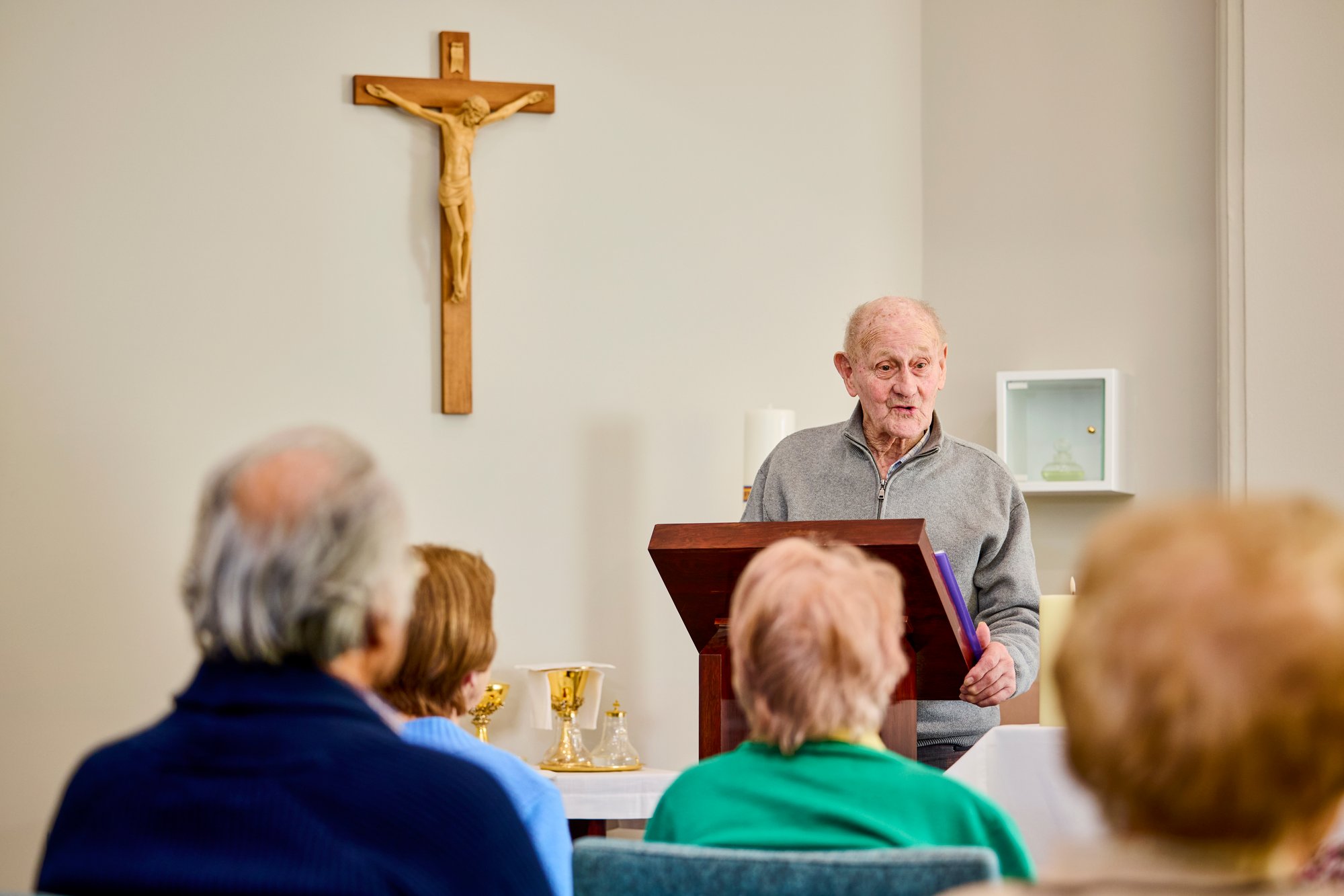 A man standing at a lectern in a church.