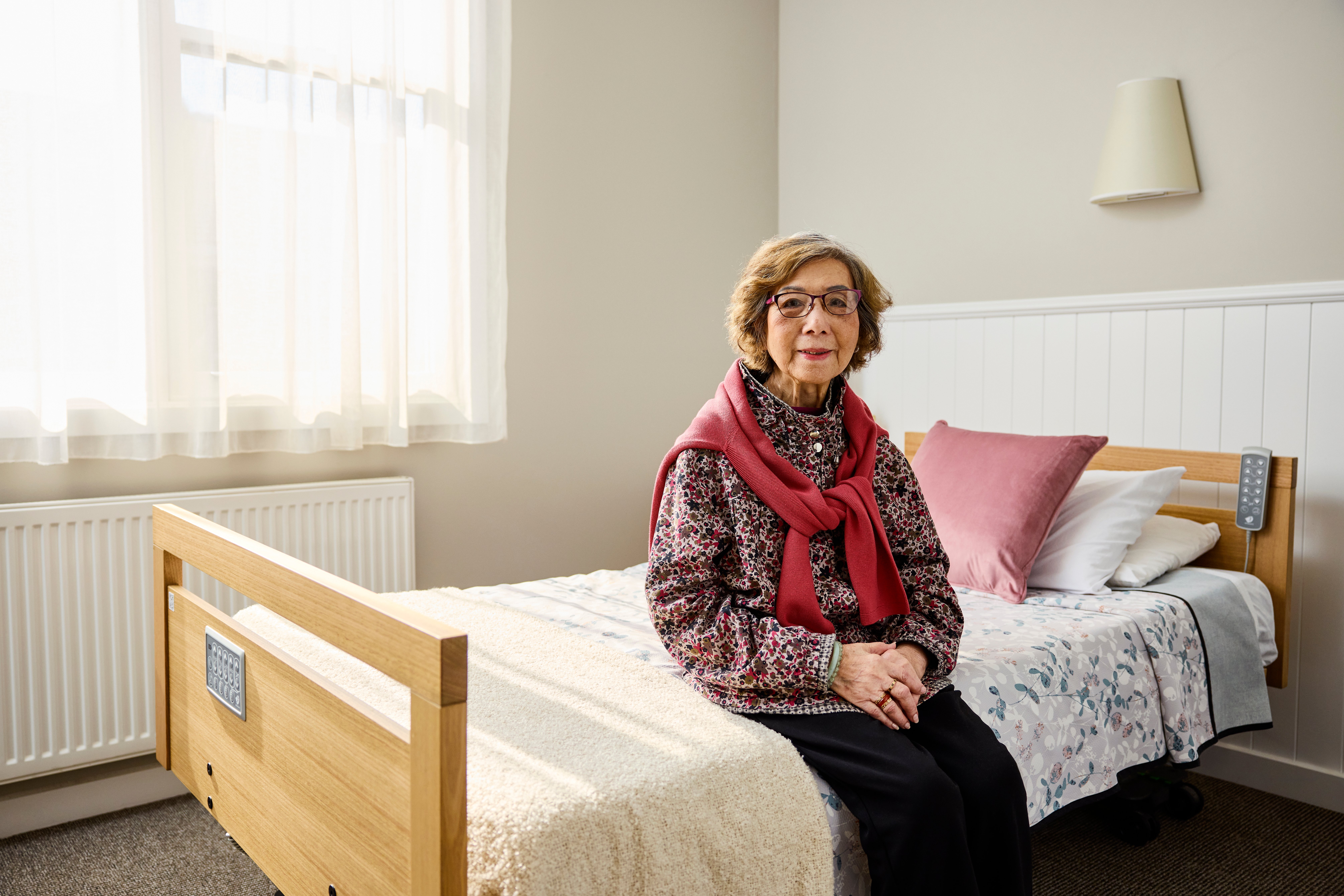 Elderly woman sitting on bed