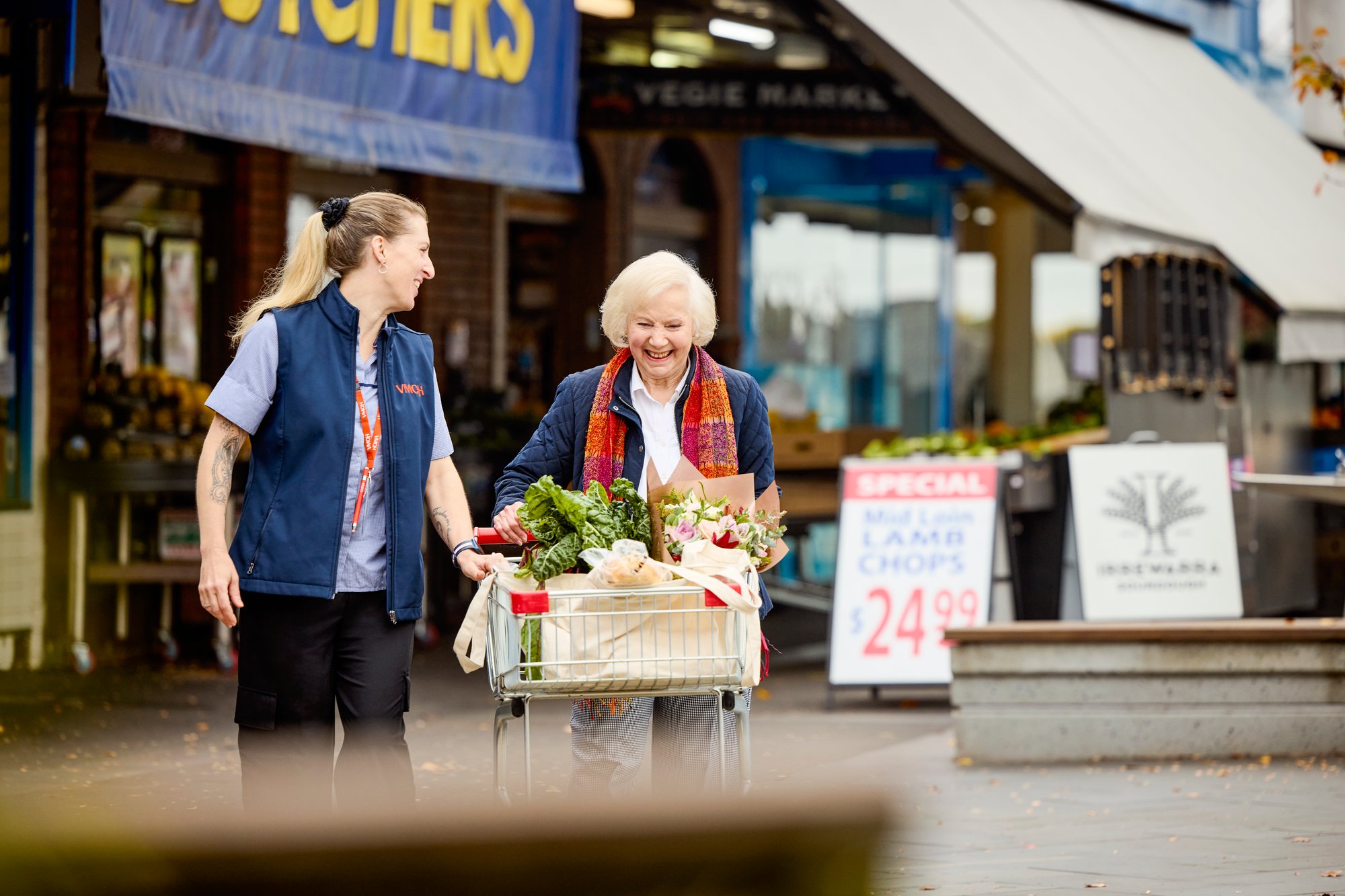 Aged care worker assisting elderly female home care resident with grocery shopping