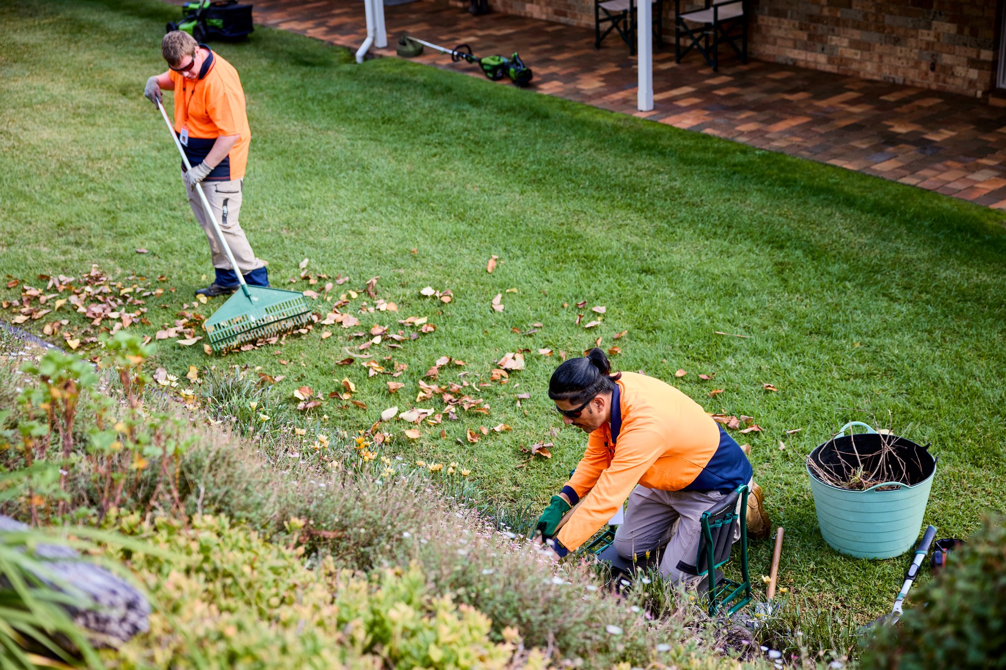 Two men in hi-vis gardening.