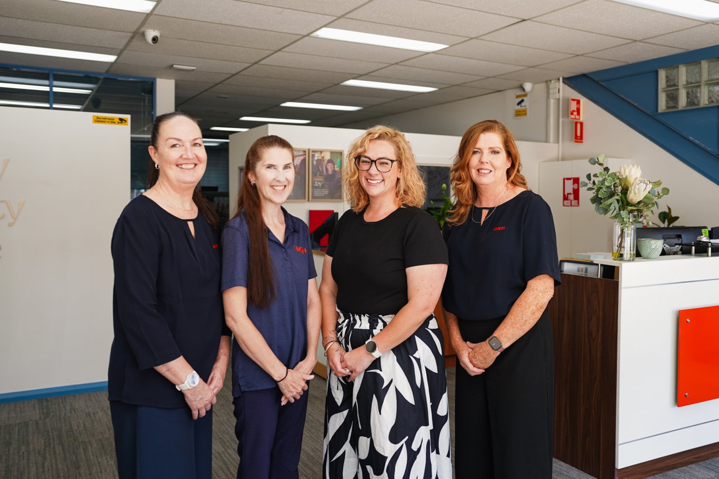 Four women posing professionally and smiling