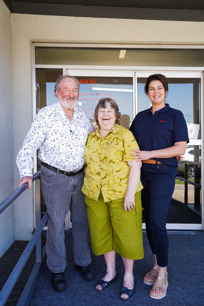 An older couple and a taller women smiling and laughing.