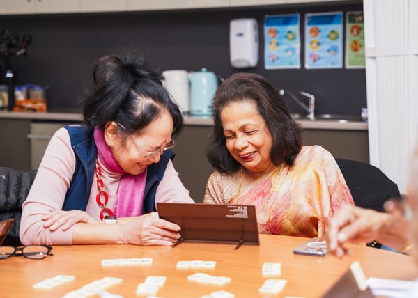 Two woman laughing while playing a word game.