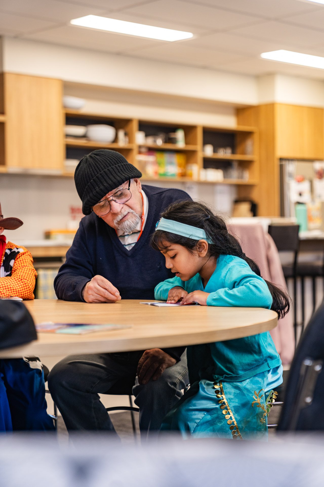 A man helping a child read.
