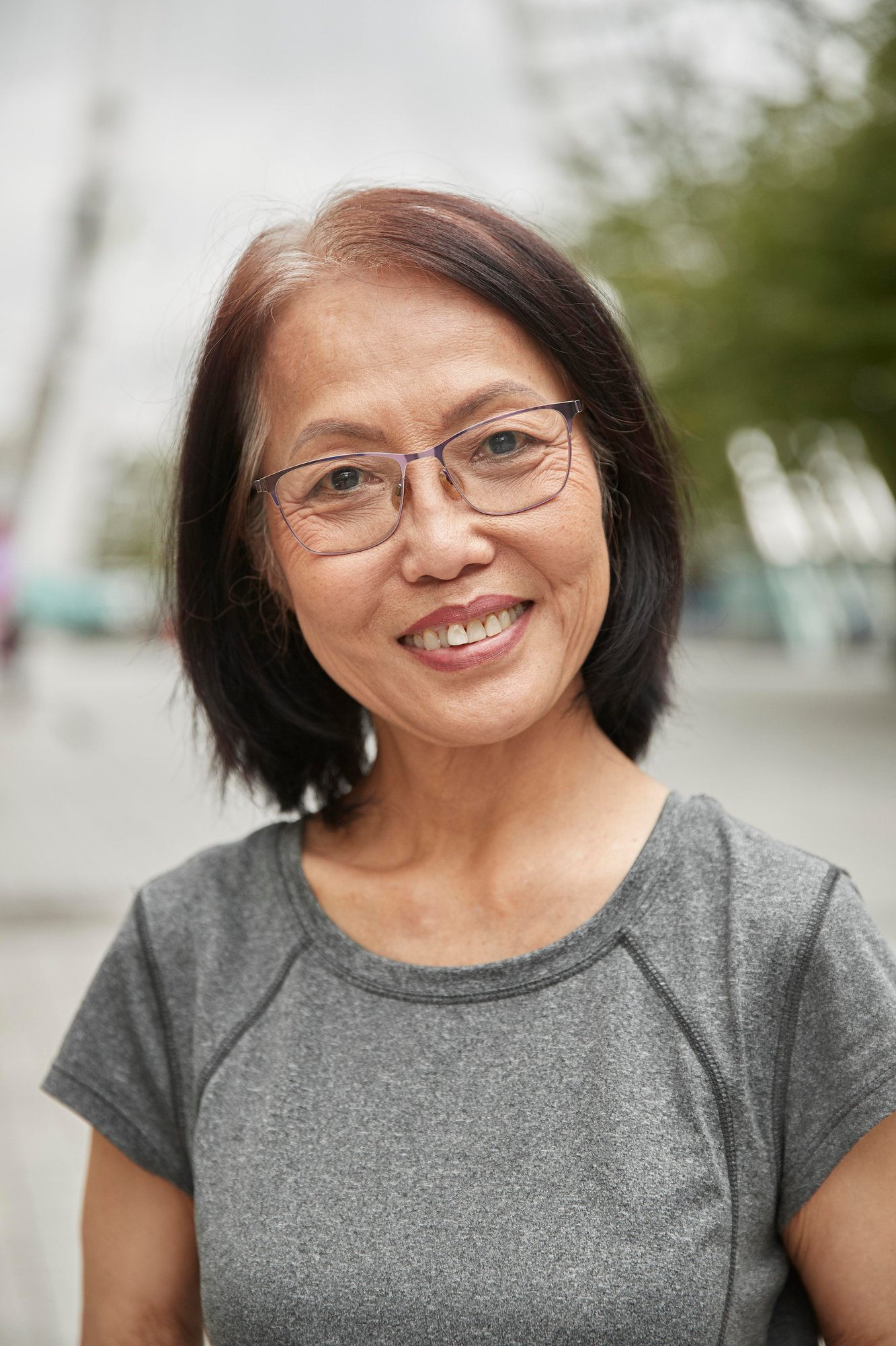 A woman wearing glasses and a grey shirt.