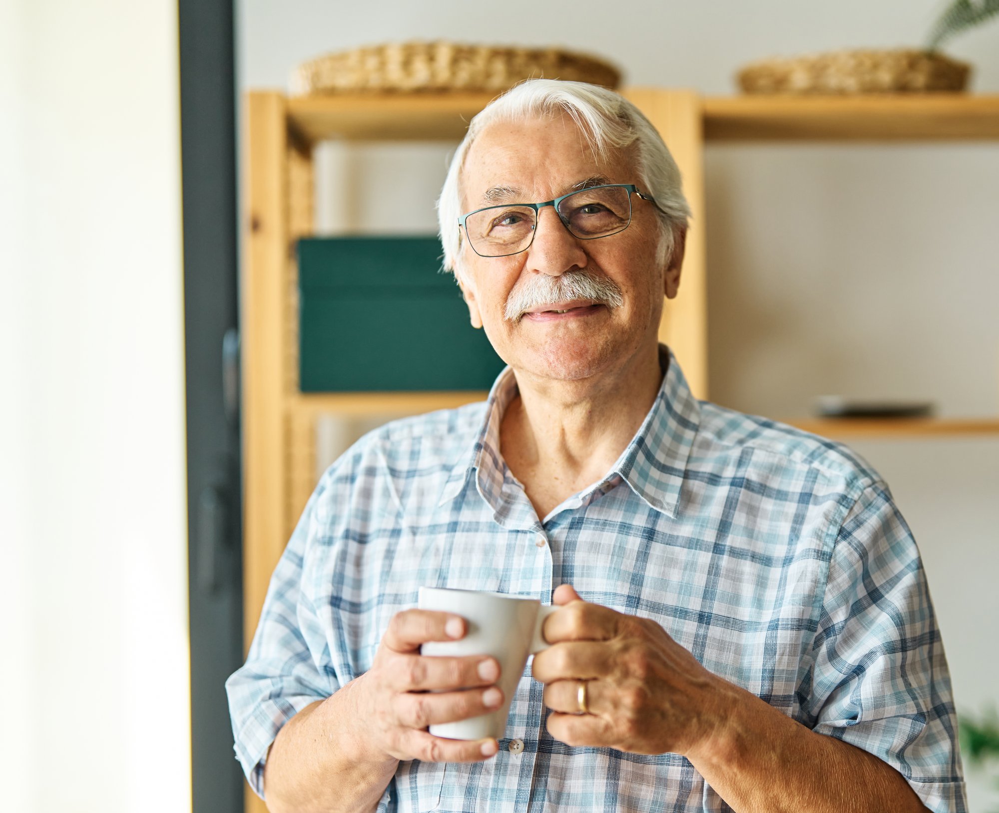 An older man smiling in a bakery.